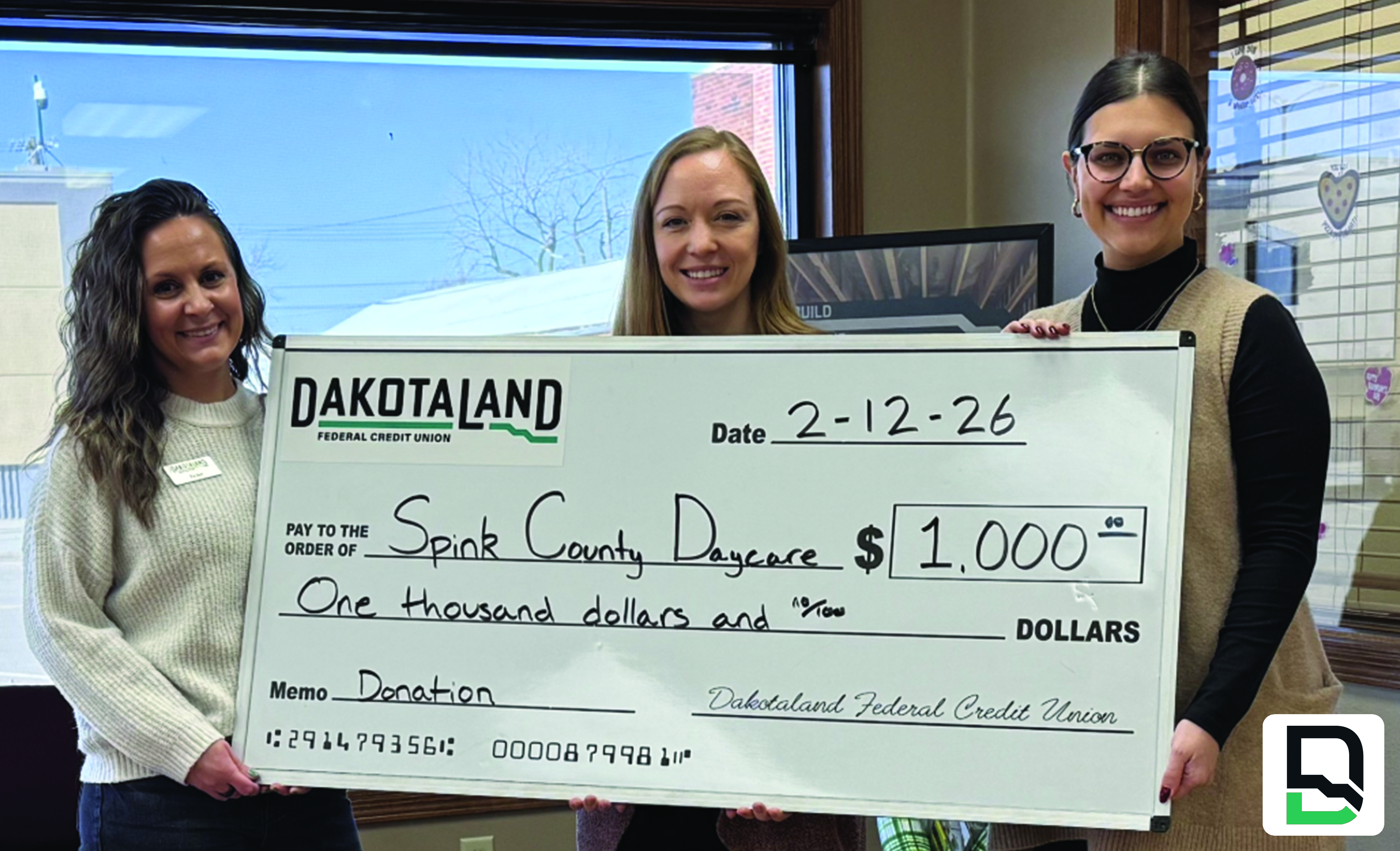 Redfield staff holding large check in donation presentation