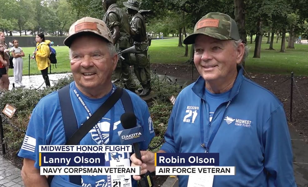 Lanny and Robin Olson stand outslide while being interviewed by news reporter