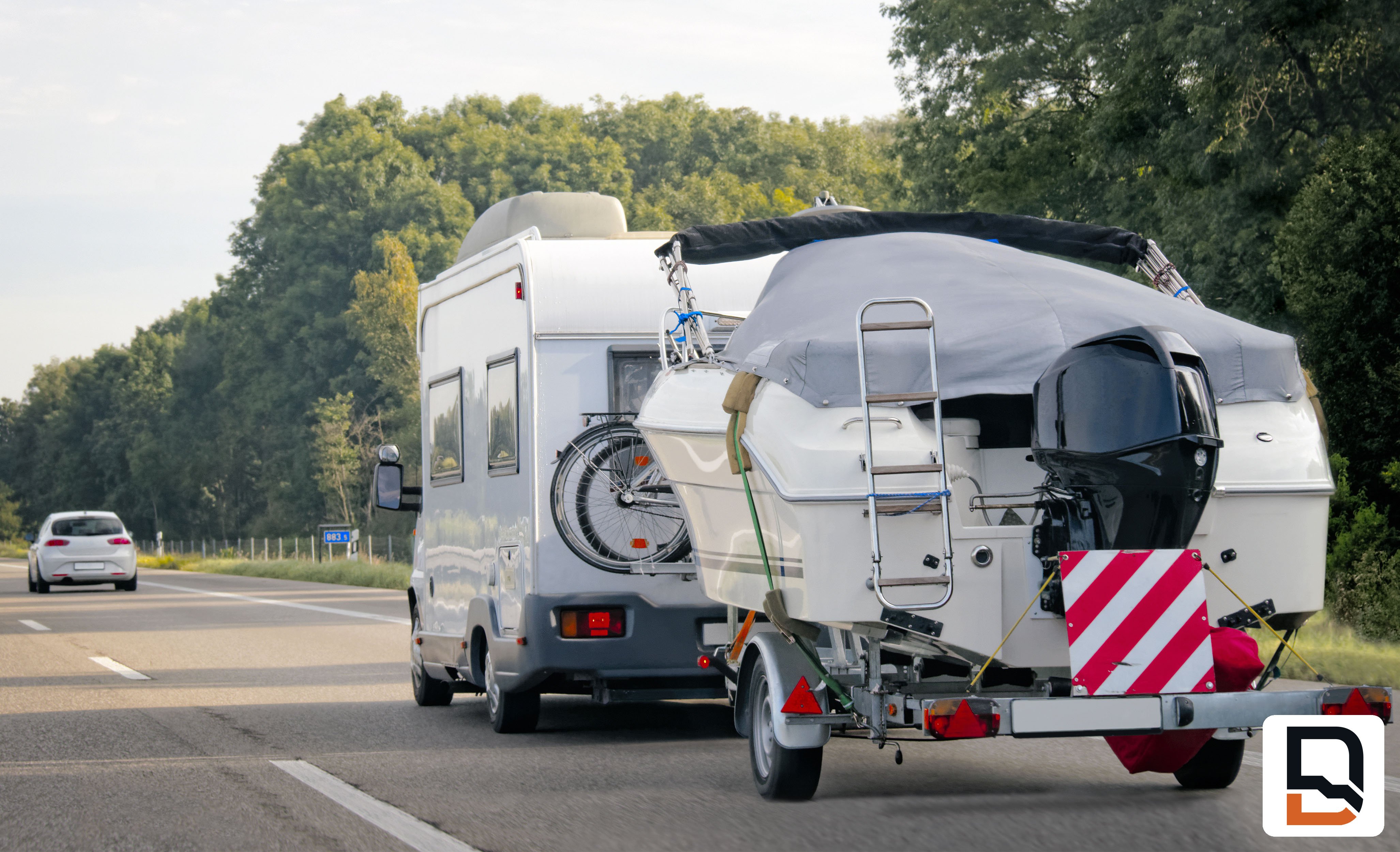 Camping towing boat down tree lined road